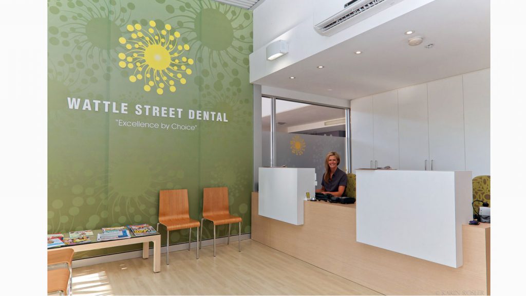 Dental practice receptionist office branded wall